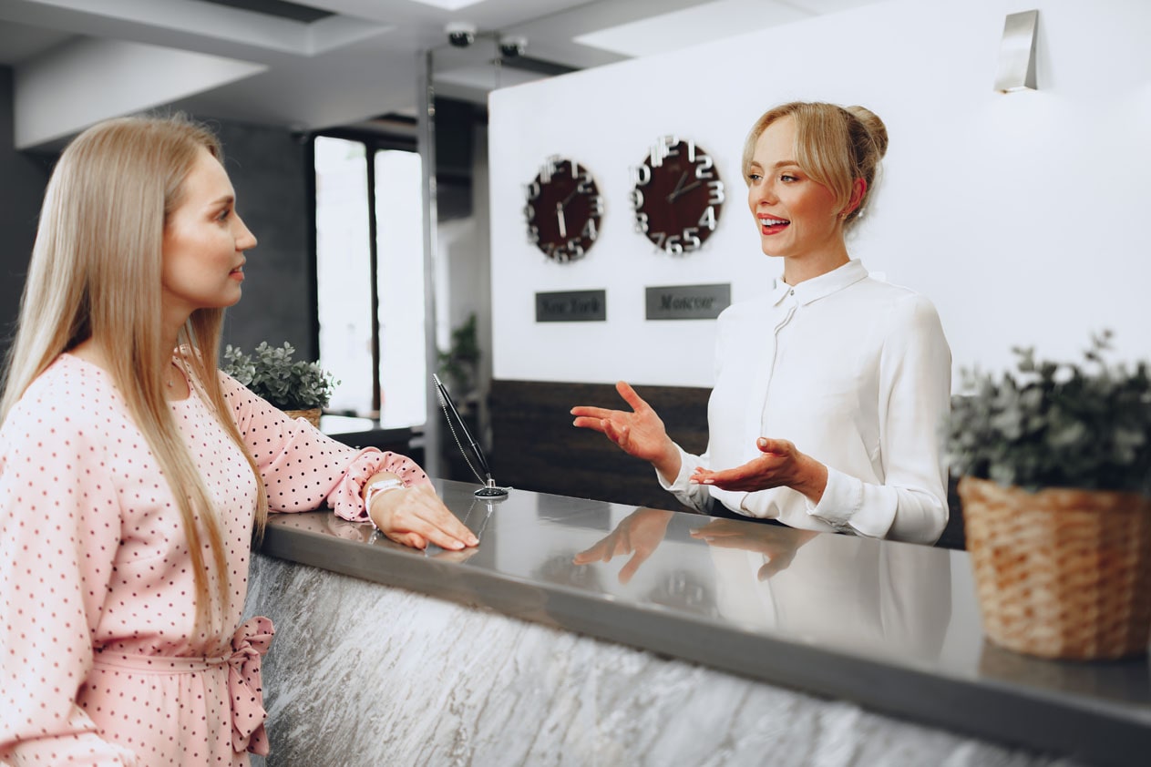 A Receptionist greeting a client as they enter the office