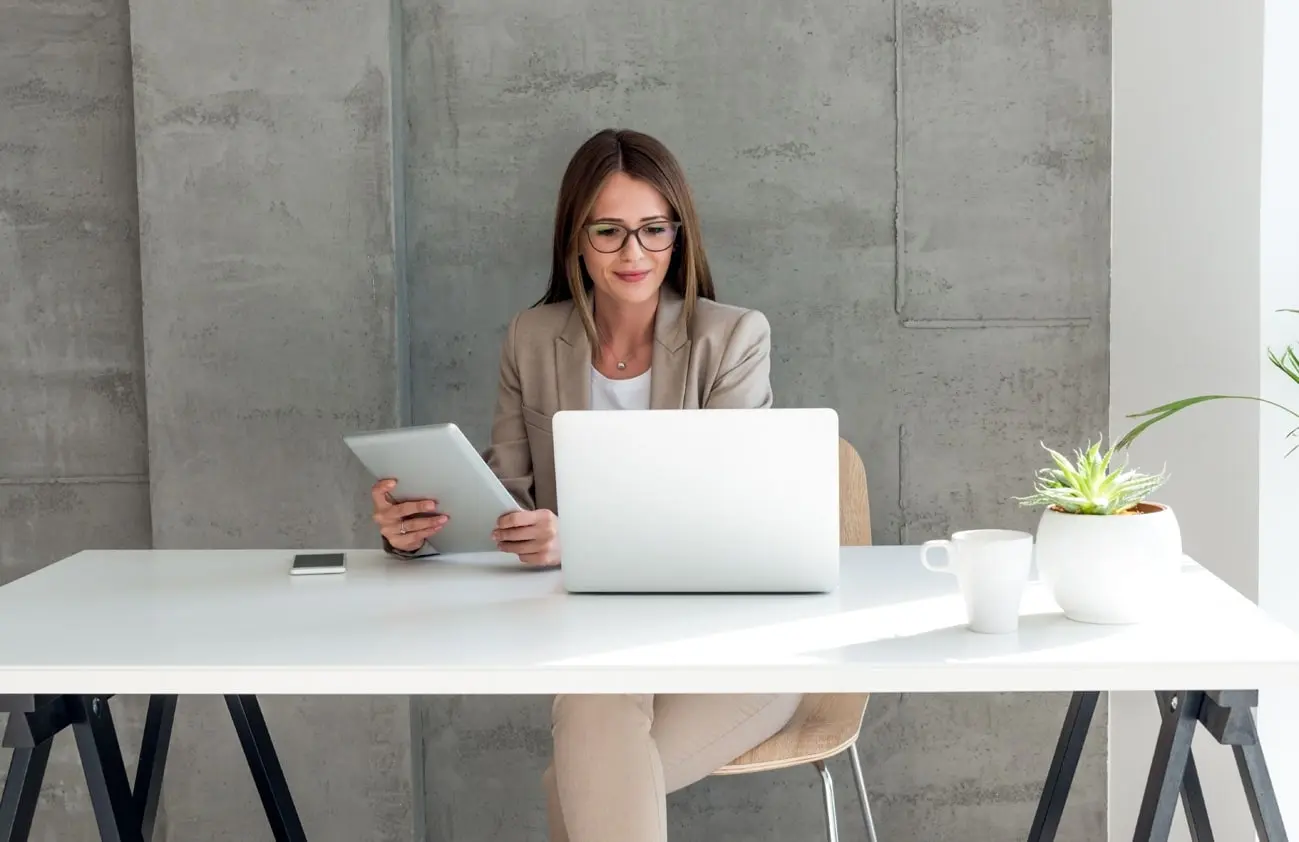 A young woman working as a team assistant looking at her laptop
