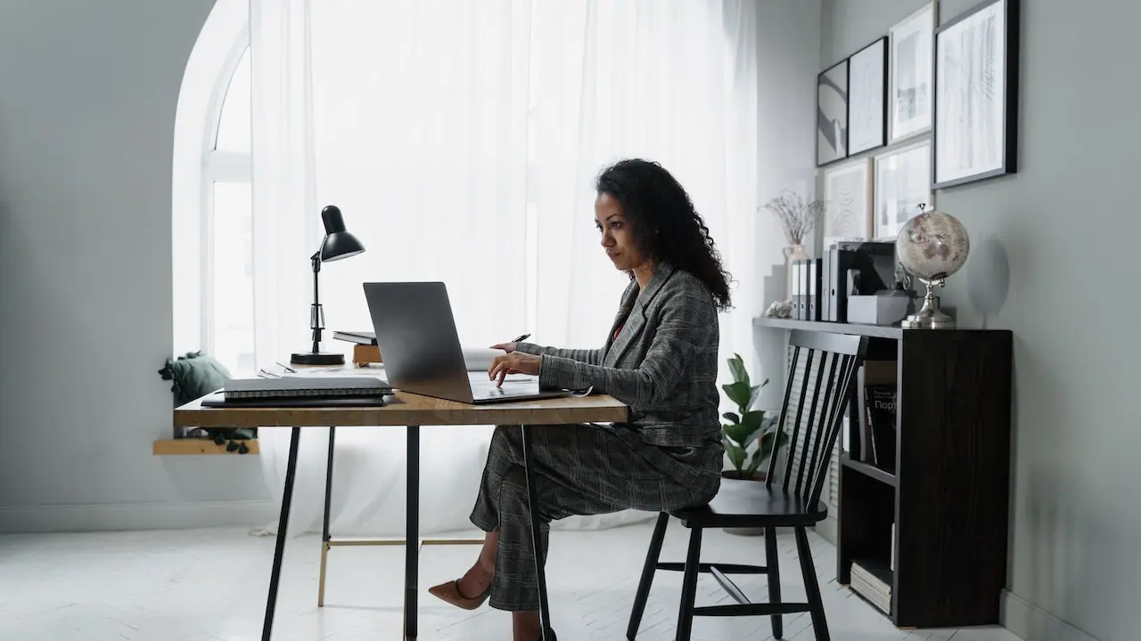 Personal assistant at an office desk working on her laptop